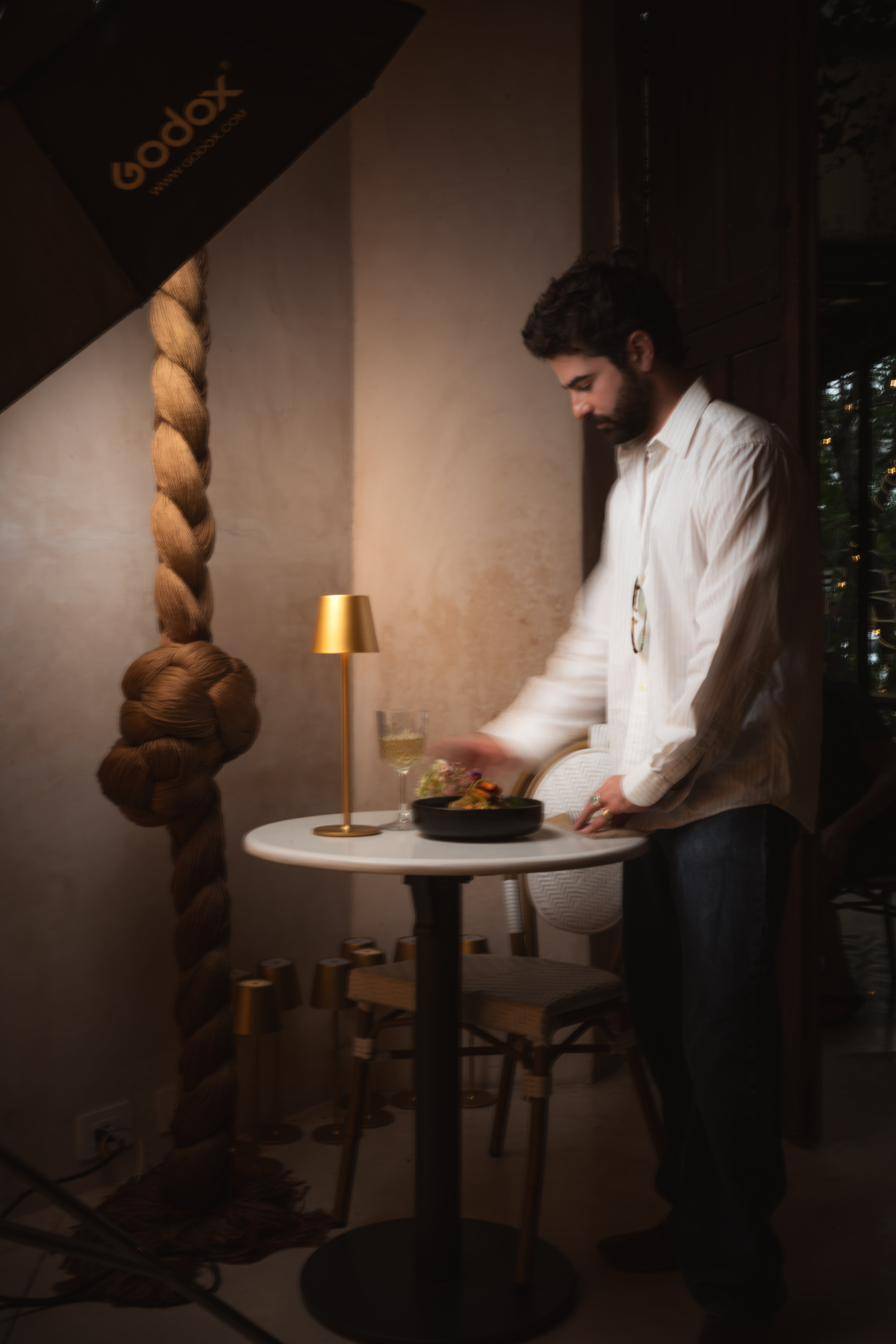 Bernardo, quien cuida todo lo visual de la casa, preparando una mesa.