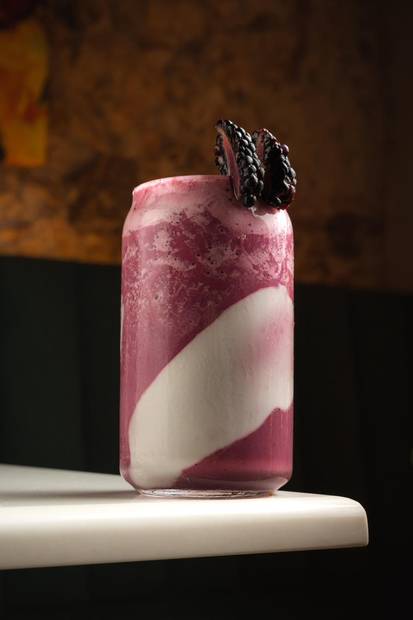 Bebida en lata de vidrio con frutos rojos sobre la barra