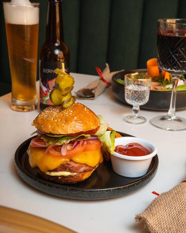 Hamburguesa con papas y cerveza en la mesa
