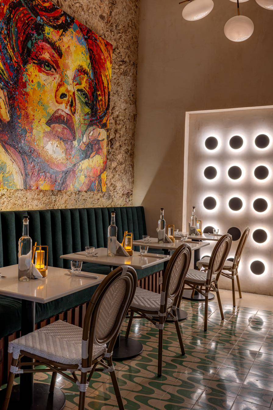 El comedor, con su banca de terciopelo verde y el gran mural.